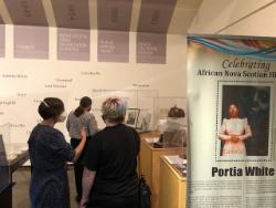 A display of individuals looking at exhibits in a museum.