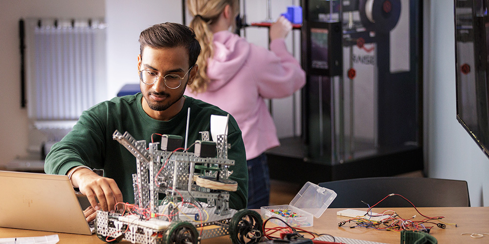 A student working on a small robot.