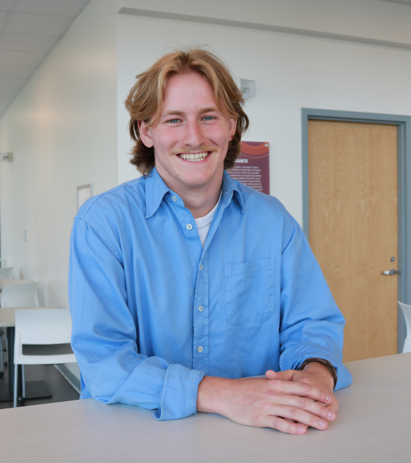 Griffin is a white man with blond hair. He wears a blue shirt.