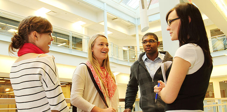 Students meeting in a hallway.