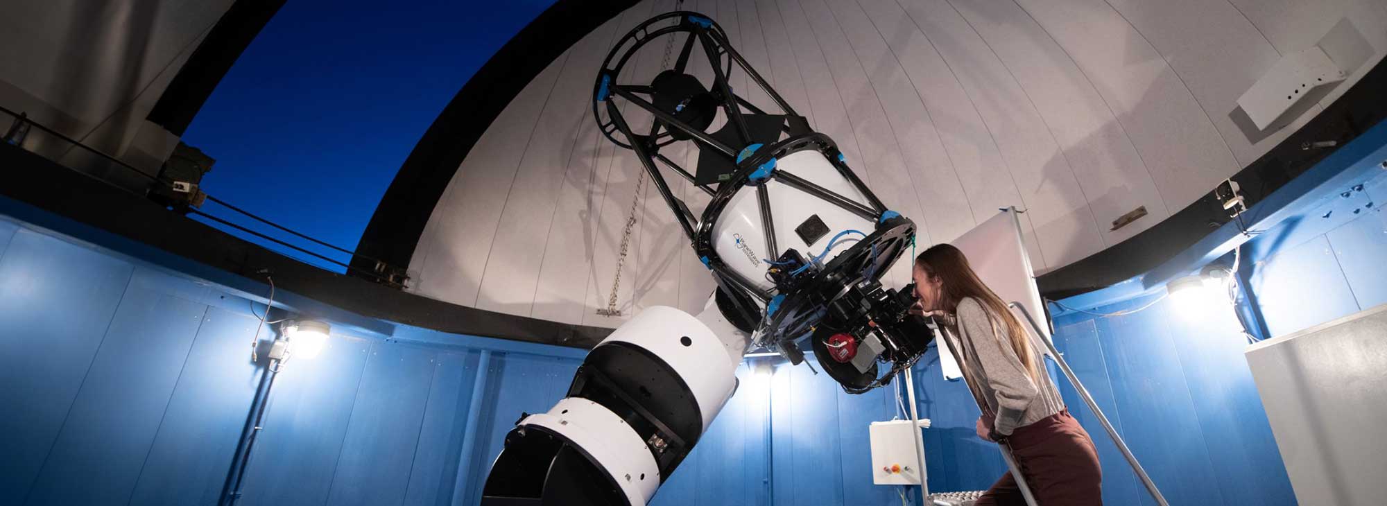 A person looking through a telescope.