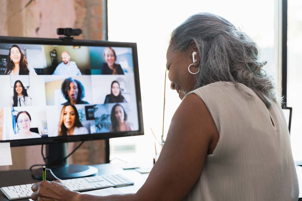 Woman viewing a computer screen showing a conference call.